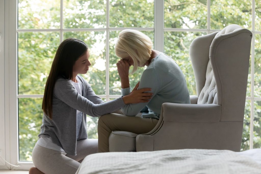 Adult daughter offering emotional support to her elderly parent living with dementia.”